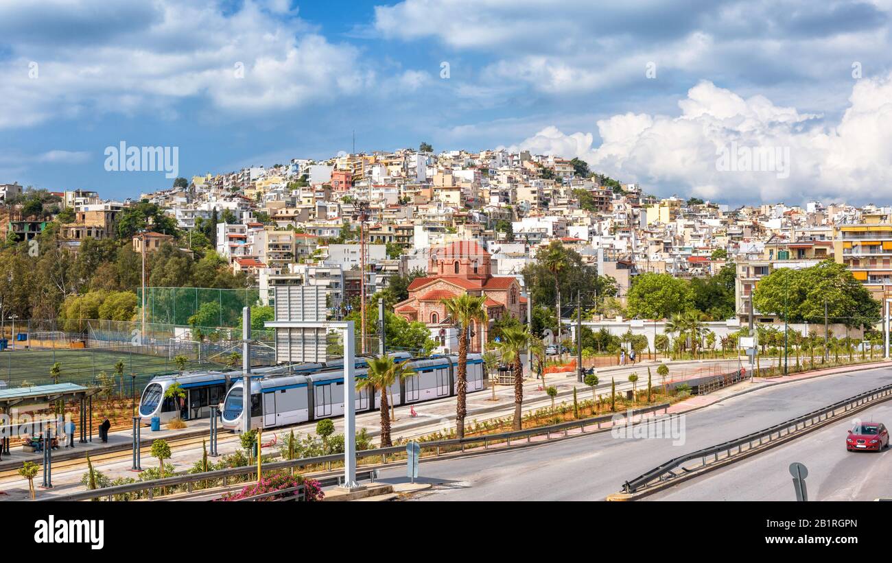 Vista panoramica del Pireo vicino Atene, Grecia. Soleggiato paesaggio urbano del Pireo con tram e strada. Scenario di una città su una collina in estate. Foto Stock