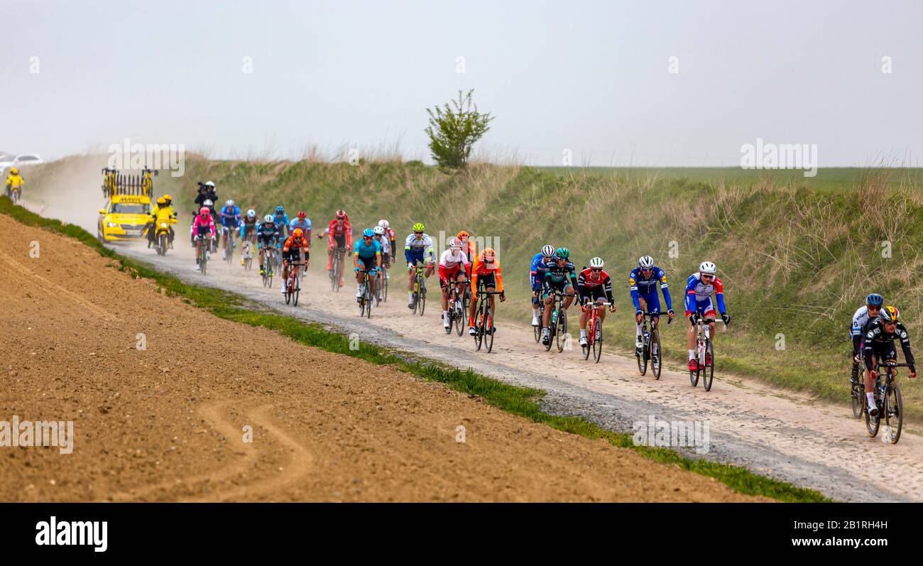Viesly, Francia - 14 aprile 2019: Il peloton che guida sulla strada acciottolata polverosa da Briastre a Viesly durante Parigi Roubaix 2019. Foto Stock