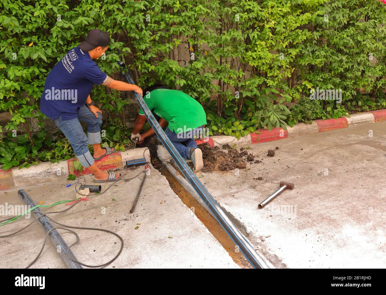 Bangkok, Thailandia - 27 febbraio 2020: Un lavoratore che scavano un buco e alberi da taglio, come nel processo di posa tubo d'acqua nella trincea Foto Stock