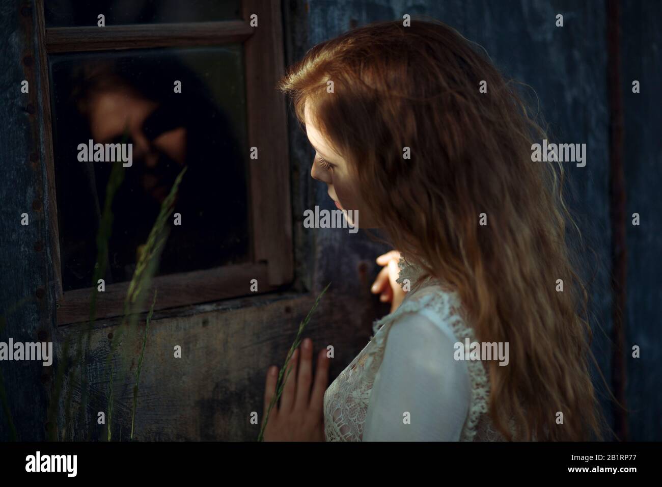 Giovane donna con riflessione nella finestra, Foto Stock