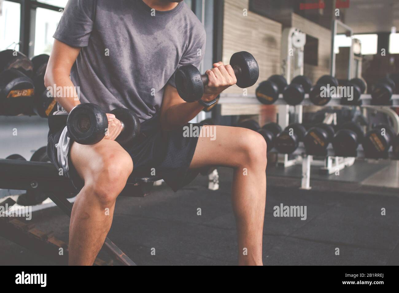 Closeup di un uomo sottile che fa esercizi con dumbbell. Fitness corpo muscolare. Concetto di fitness Foto Stock