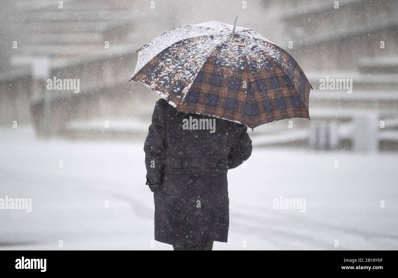 Stoccarda, Germania. 27th Feb, 2020. Un uomo sta portando un ombrello innevato vicino alla fiera. Credito: Marijan Murat/Dpa/Alamy Live News Foto Stock