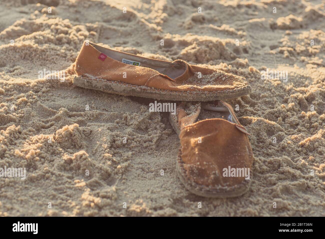 Scarpe in tela su una spiaggia di sabbia Foto Stock