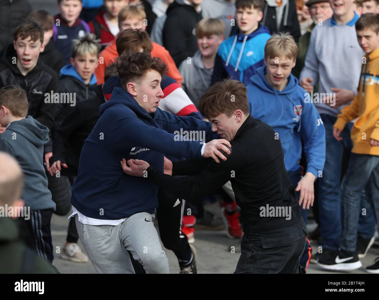 Boys tussle per la palla di pelle durante l'annuale Jedburgh ba 'game event on Jedburgh's High Street in the Scottish Borders.Picture date: Giovedì 27 febbraio 2020. L'evento annuale è iniziato nella 1700s e il primo gioco mai è stato presumibilmente giocato con la testa di un inglese. Si tratta di due squadre, Uppies (residenti dalla parte superiore di Jedburgh) e le Doonies (residenti dalla parte inferiore di Jedburgh) ottenere la palla o la parte superiore o inferiore della città. La palla, realizzata in pelle, ripiena di paglia e decorata con nastri che rappresentano i capelli, viene gettata nella folla Foto Stock