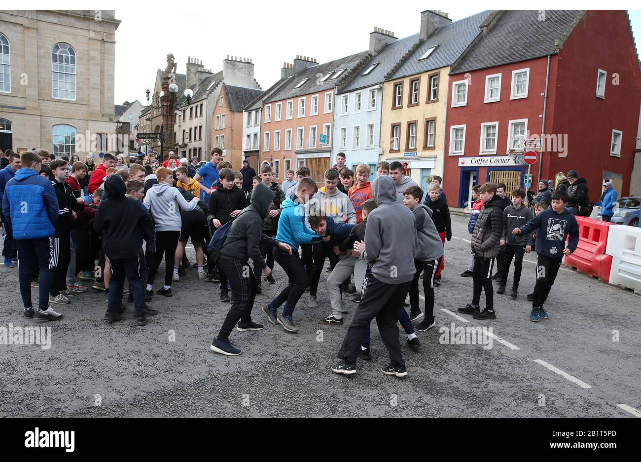 Boys tussle per la palla di pelle durante l'annuale Jedburgh ba 'game event on Jedburgh's High Street in the Scottish Borders.Picture date: Giovedì 27 febbraio 2020. L'evento annuale è iniziato nella 1700s e il primo gioco mai è stato presumibilmente giocato con la testa di un inglese. Si tratta di due squadre, Uppies (residenti dalla parte superiore di Jedburgh) e le Doonies (residenti dalla parte inferiore di Jedburgh) ottenere la palla o la parte superiore o inferiore della città. La palla, realizzata in pelle, ripiena di paglia e decorata con nastri che rappresentano i capelli, viene gettata nella folla Foto Stock