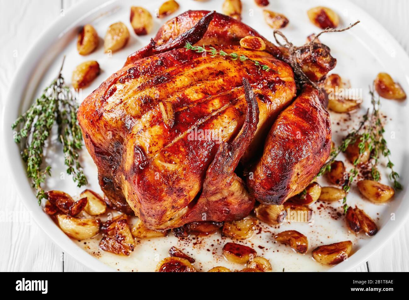 Pollo arrosto con Quaranta Chiodi Di Garlic su un piatto bianco, su un tavolo di legno, cucina francese, vista orizzontale dall'alto, primo piano Foto Stock