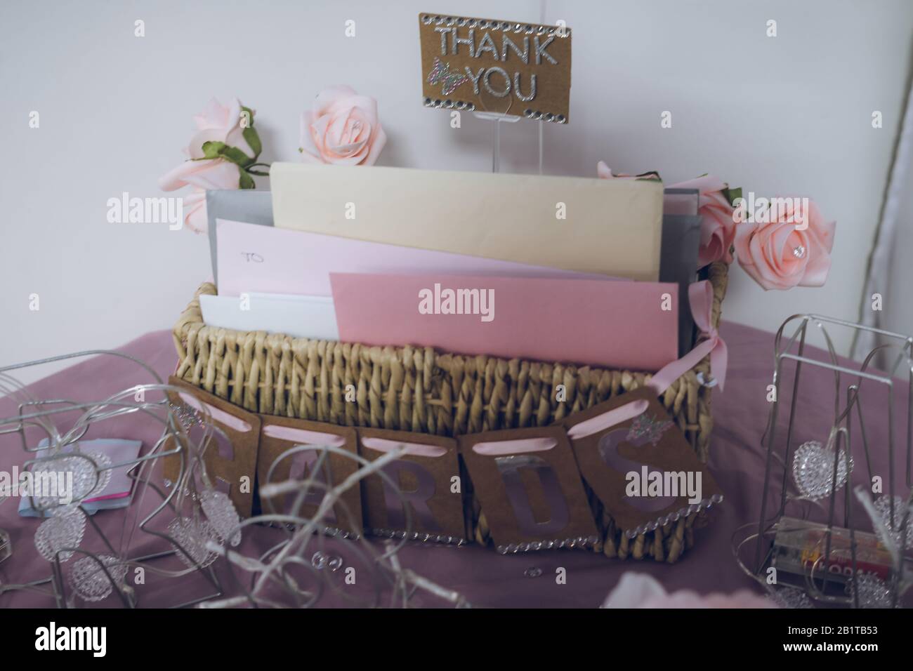 una scatola riempita con le schede circondate dalle decorazioni su un tavolo alle schede del ricevimento di nozze sono messe in come regalo per la sposa e lo sposo newlywed Foto Stock