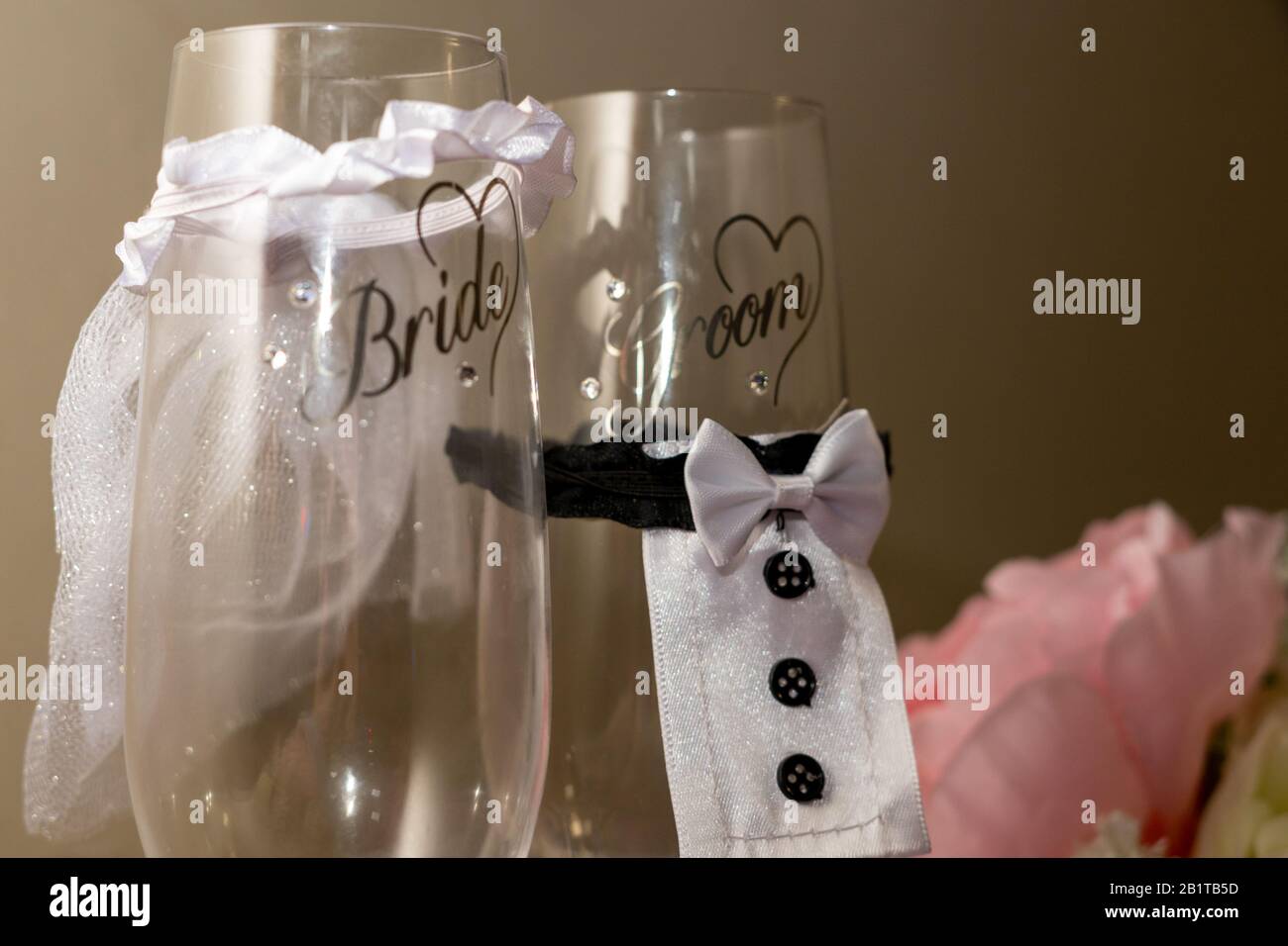 due nuovi flute champagne o bicchieri champagne con le parole sposa e sposo scritto su di loro Foto Stock