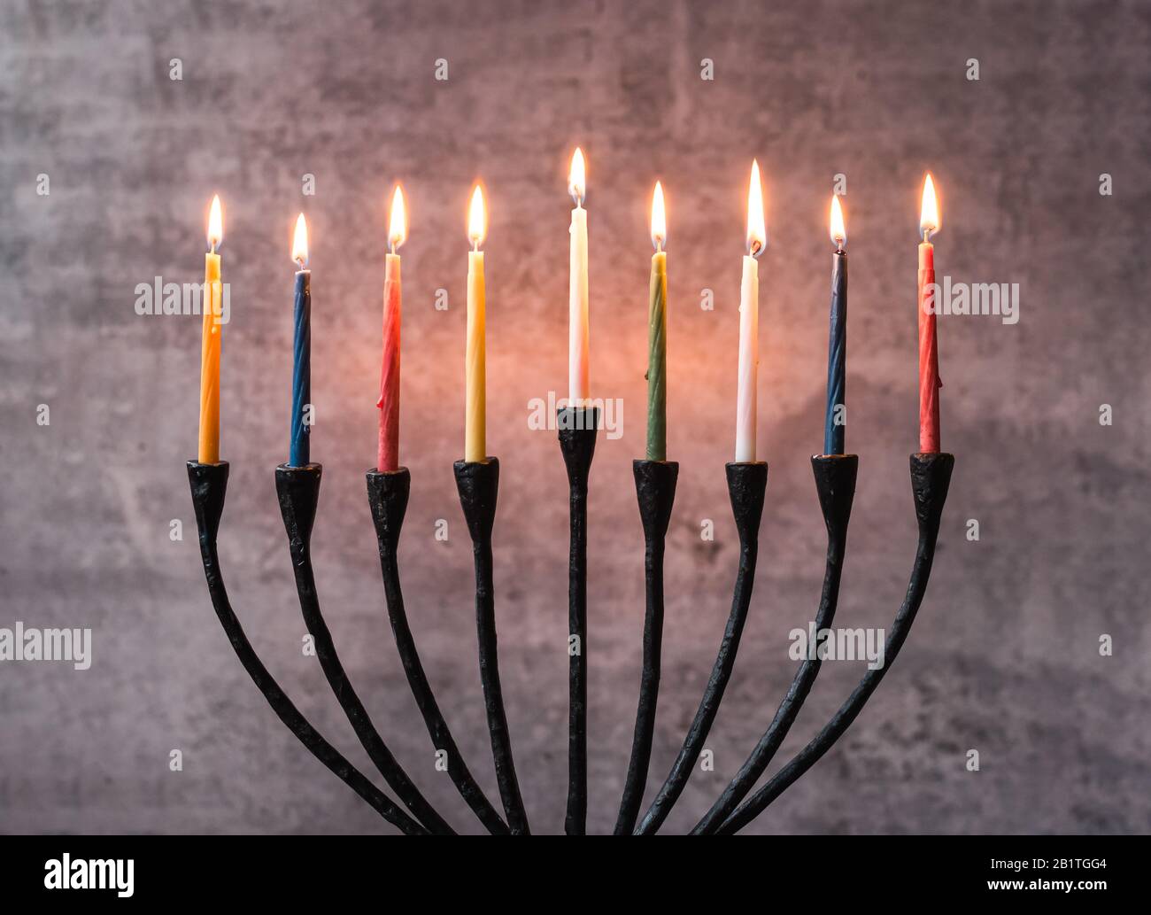 Primo piano di candele accese su un menorah per le celebrazioni Hanukkah. Foto Stock