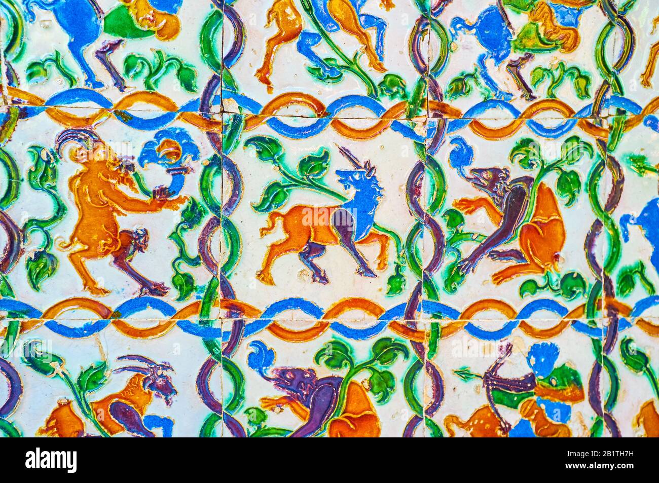 Le colorate Azulejos (piastrelle smaltate) sulle pareti dei Giardini Alcazar con immagini di creature mitologiche e motivi geometrici, Siviglia, Spagna Foto Stock