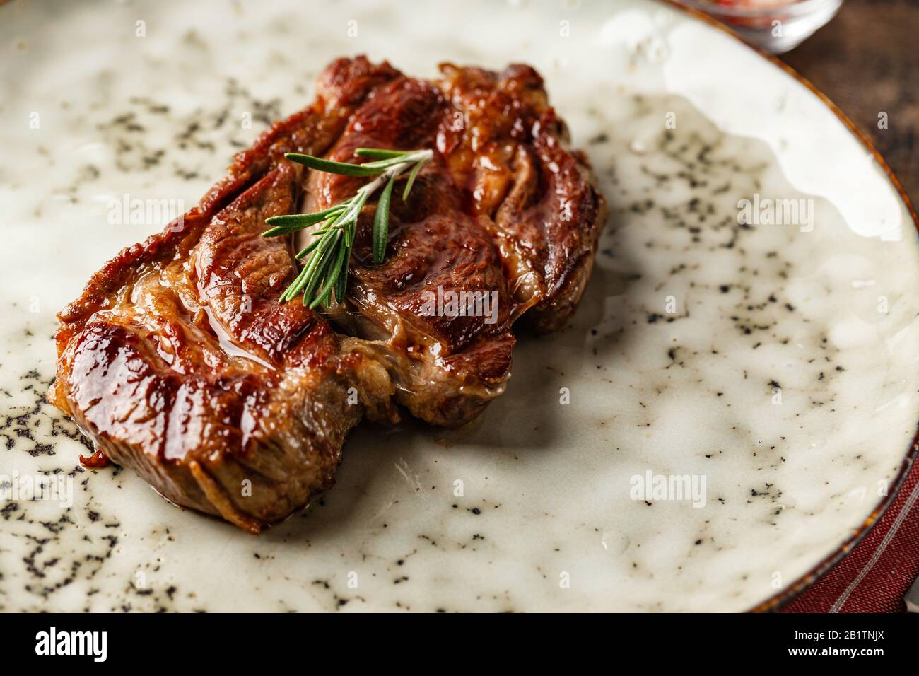 Bistecca di manzo alla griglia prime Black Angus Chuck bistecca su un piatto su un tavolo di legno Foto Stock