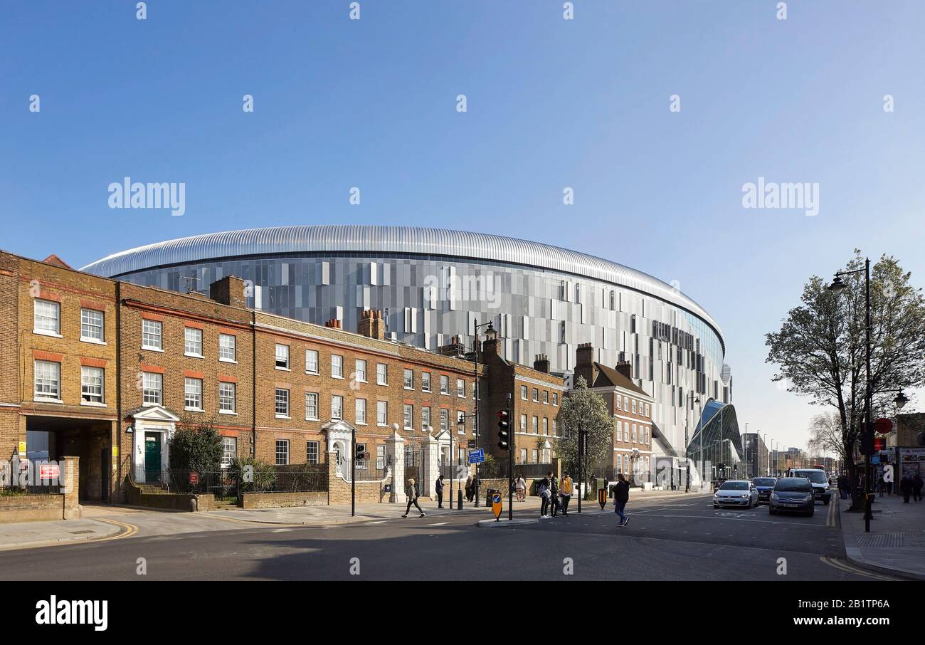 Giustapposizione della facciata dello stadio all'alloggio a schiera. Il New Tottenham Hotspur Stadium, Londra, Regno Unito. Architetto: Popoloso, 2019. Foto Stock