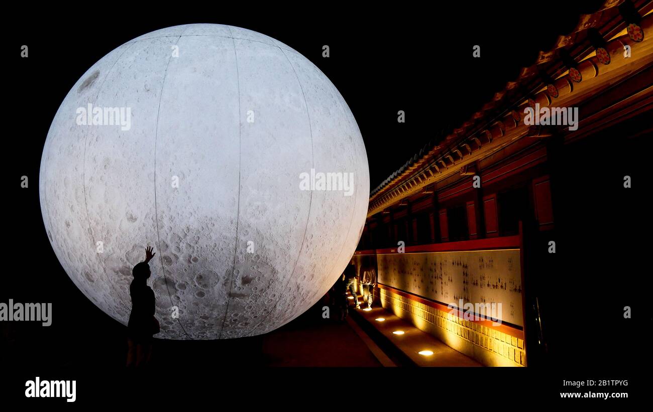 Una ragazza accarezza la luna a Suwon (Corea del Sud) Foto Stock