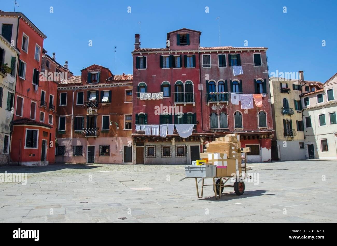 Carrello con box al centro della vecchia piazza italiana con colorati edifici a Venezia, Italia. Servizio postale, consegna in Italia. Caselle lasciate da sole Foto Stock