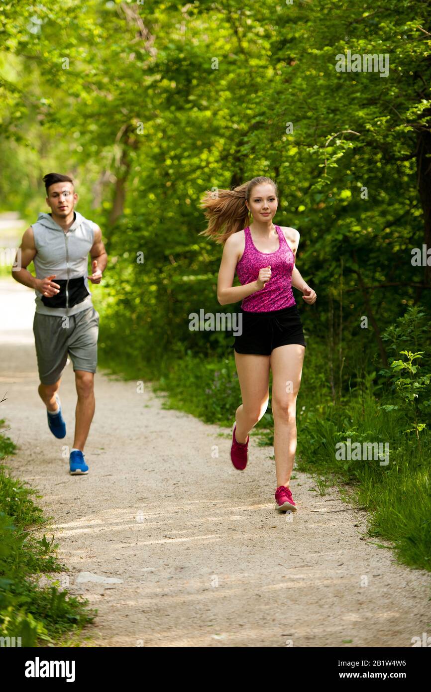 Giovane coppia attiva che corre nel parco Foto Stock