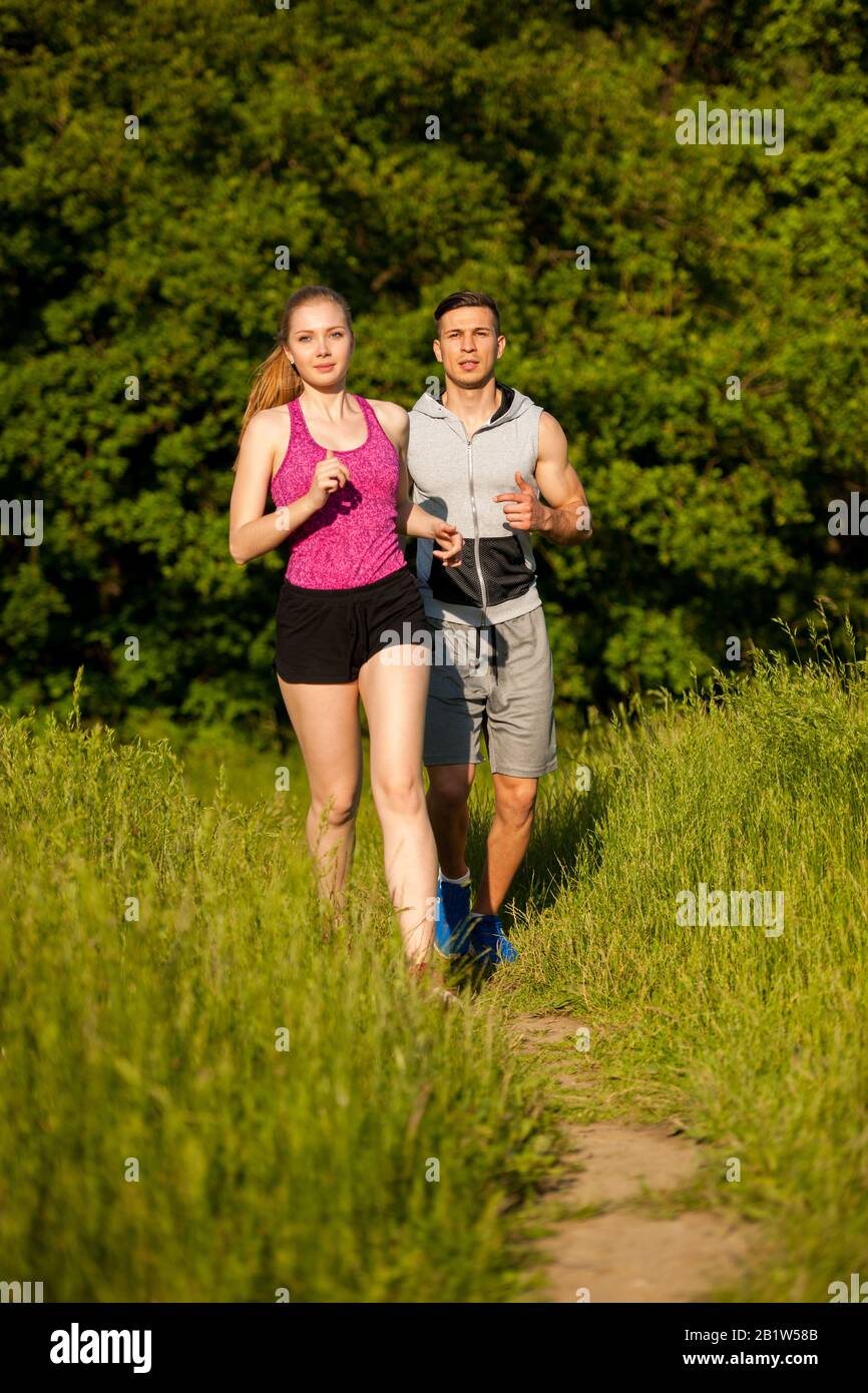 Giovane coppia attiva che corre nel parco Foto Stock