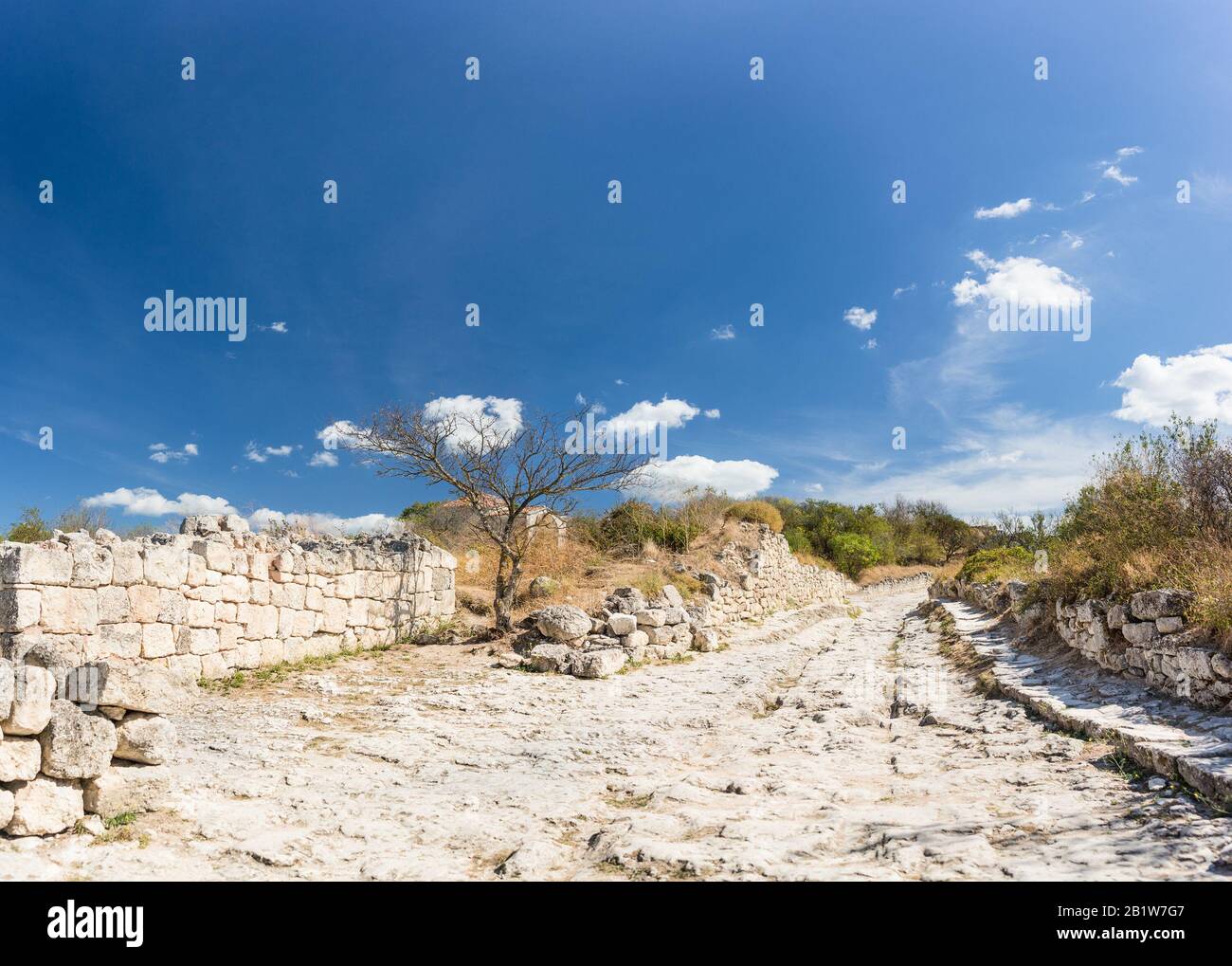 Strade deserte nella città medievale-fortezza Chufut-Kale in una calda giornata estiva. Una calda giornata di sole. Crimea, Russia Foto Stock