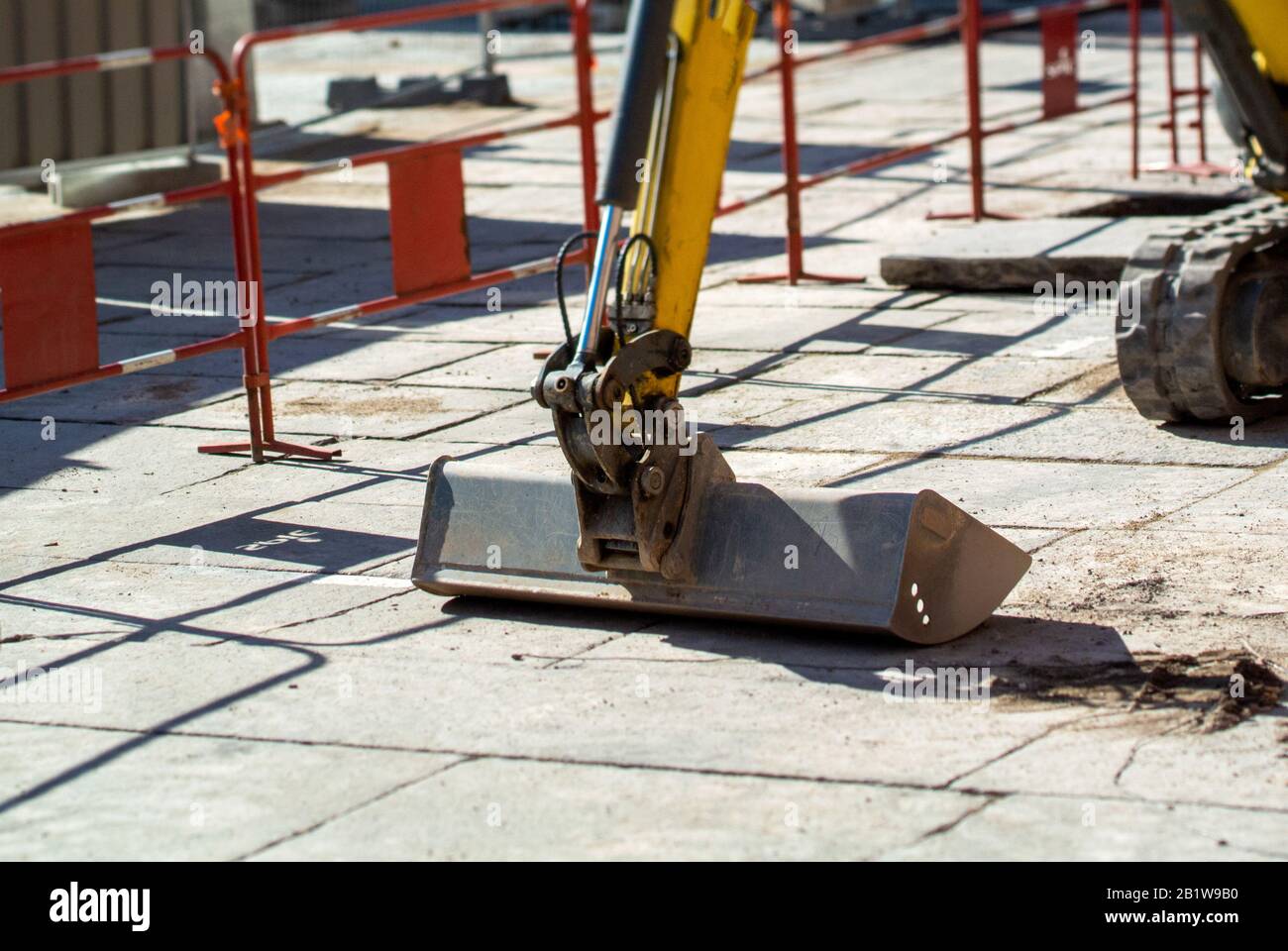 Benna per escavatore piccolo che lavora sulle grandi placche di pietra  acciottolata nella piazza centrale di Strasburgo Foto stock - Alamy