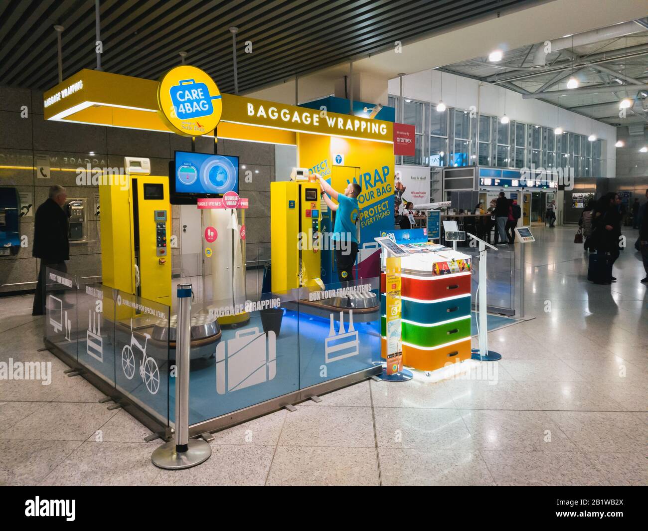 Atene, Grecia - Febbraio, 11 2020: Aeroporto Internazionale Di Atene Eleftherios Venizelos, Grecia. Servizio di imballaggio e tracciamento bagagli Care4Bag, A. Foto Stock