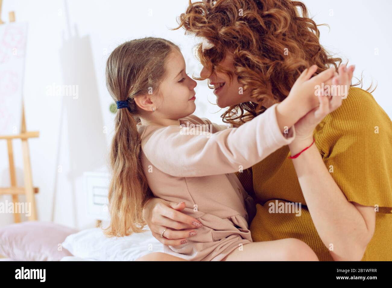 Mamma incinta gioca con sua figlia. Concetto di famiglia, gioia e gravidanza Foto Stock