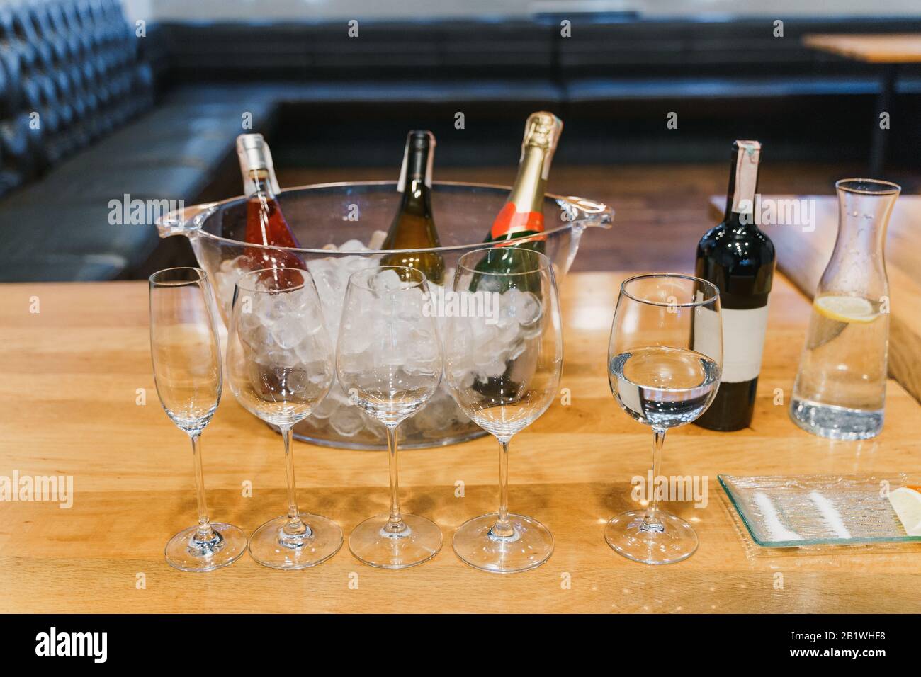 Bicchieri vuoti, bottiglia di vino assortito in una ciotola con ghiaccio Foto Stock