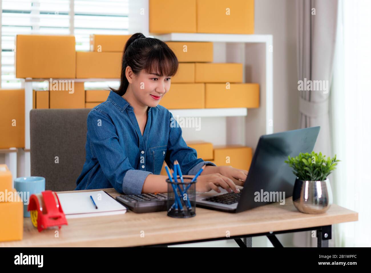 Affascinante bella asiatica adolescente proprietario business donna il lavoro a casa per lo shopping online, guardando l'ordine nel computer portatile con apparecchiature per ufficio, entreprene Foto Stock