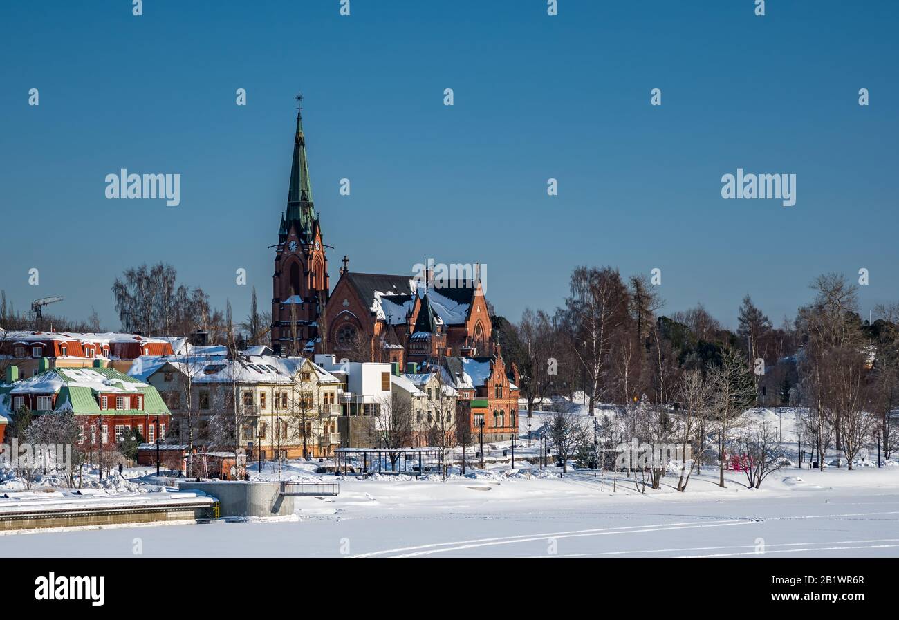 Umea City Church in inverno giorno coperto, Svezia. Surgelato Umea fiume in primo piano. Cielo azzurro, niente nuvole. Contea di Vasterbotten, Svezia. Foto Stock