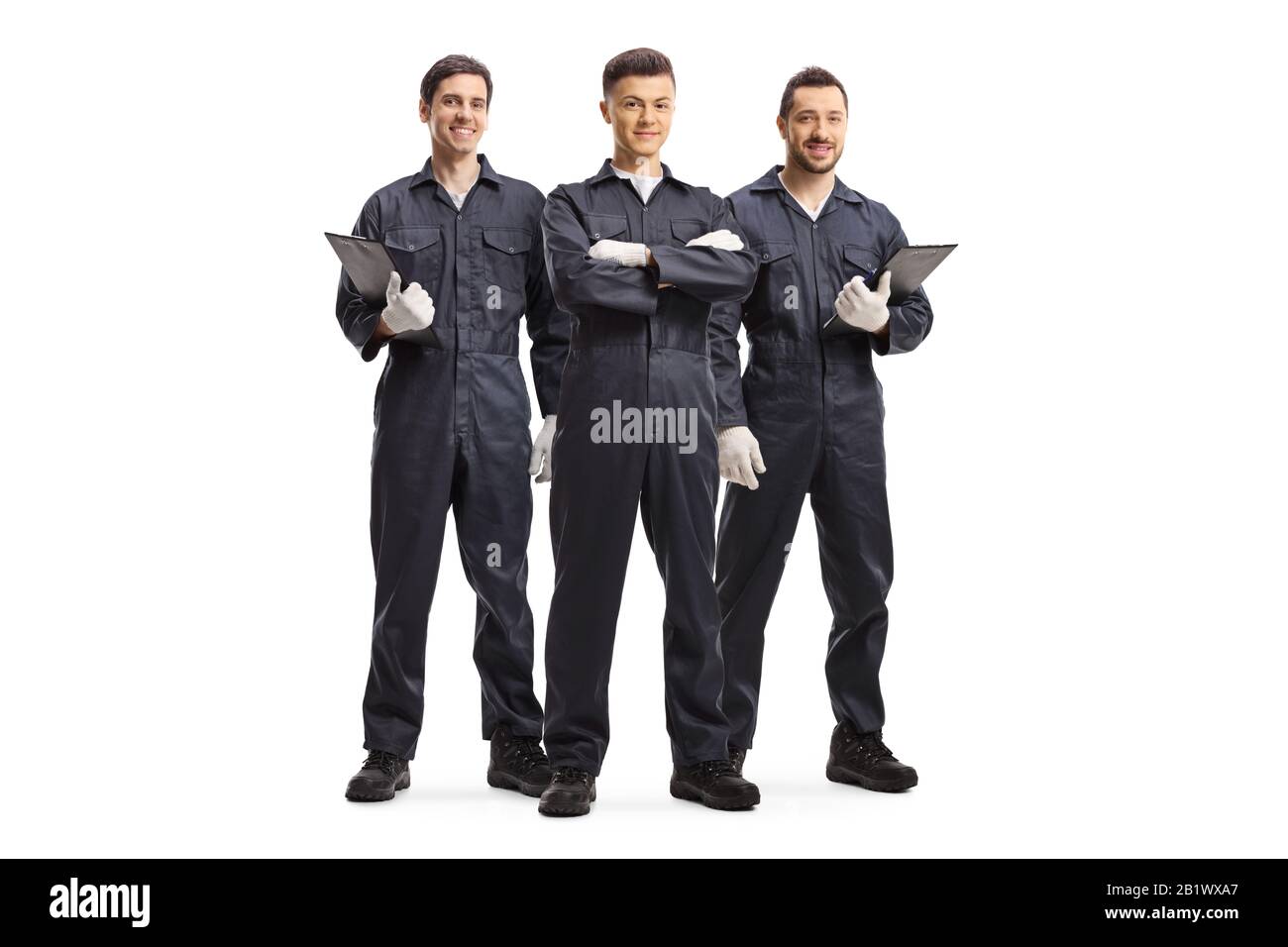 Ritratto a tutta lunghezza di tre meccanici in uniformi isolato su sfondo bianco Foto Stock