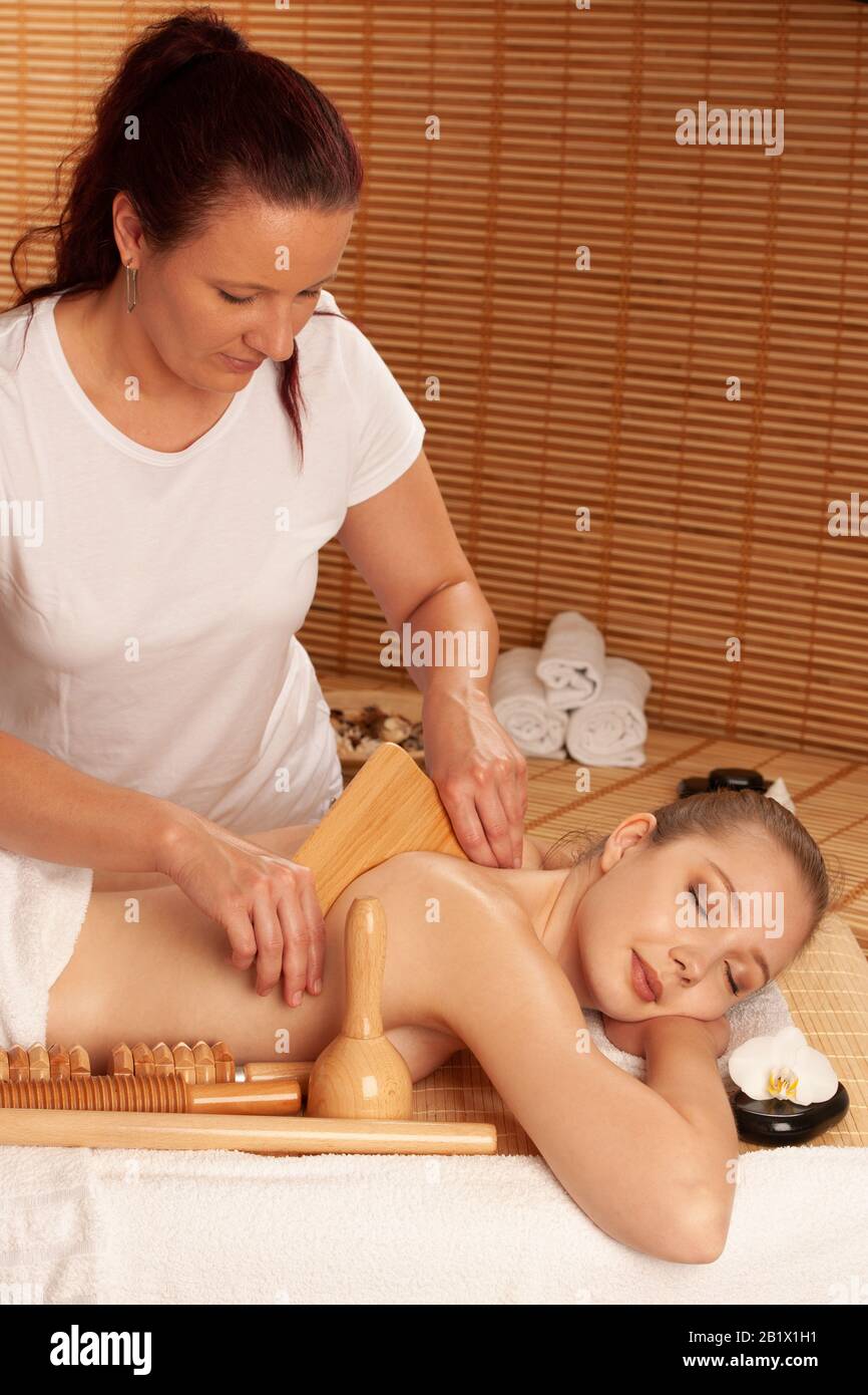 Bella giovane donna che ha un trattamento di massaggio di maderoterapia in salone di spa - benessere Foto Stock