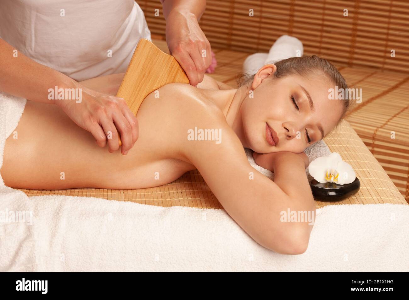 Bella giovane donna che ha un trattamento di massaggio di maderoterapia in salone di spa - benessere Foto Stock