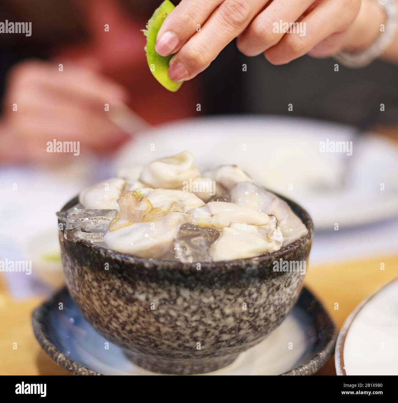 Pesce Fresco tailandese Concentrato selettivo: Ostriche fresche e deliziose servite su ghiaccio, mangiare crudo con succo di lime appena spremuto. Nutrizione, Cibo, Cucina, Tailandese Foto Stock