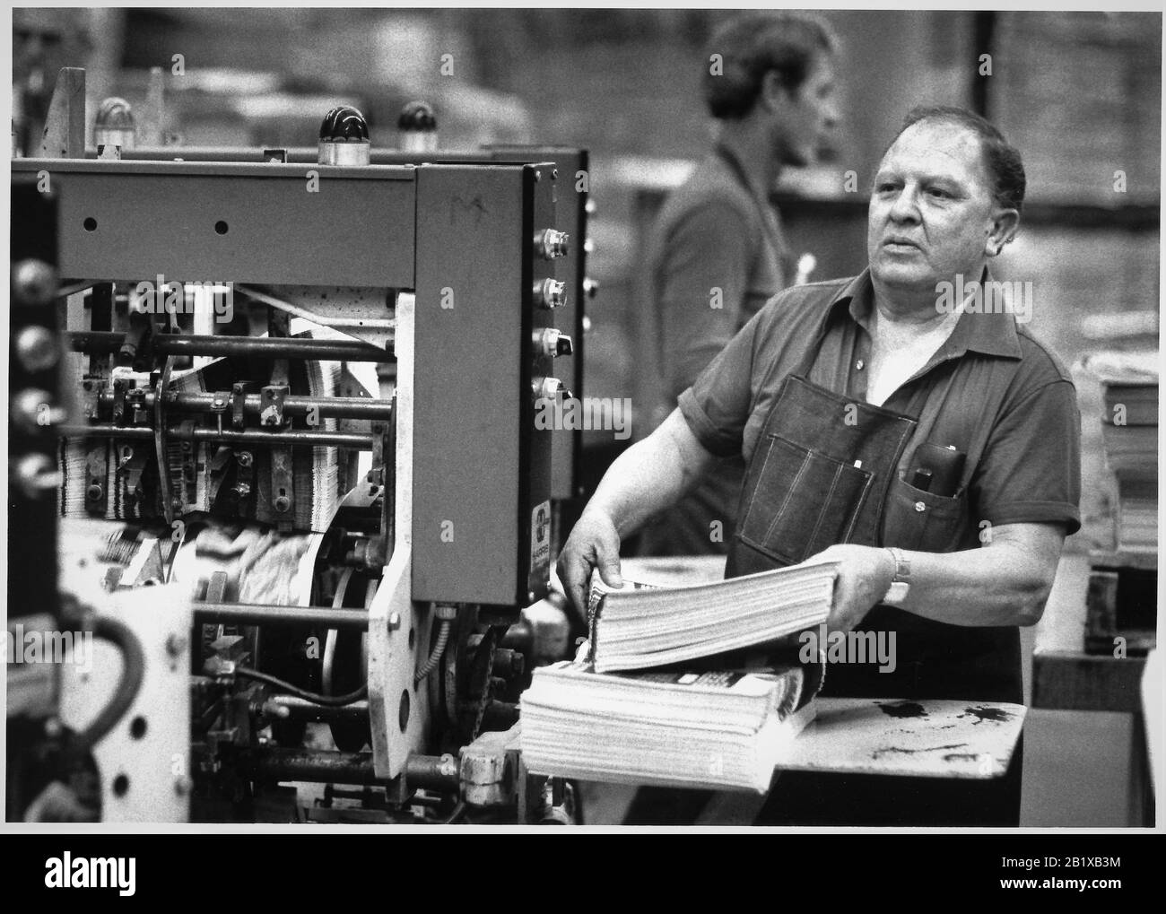 Senior 'inserter' aggiunta di inserti alla cartella della stampa offset Long Beach locale come un lavoro che è pericoloso e paga bene ogni giorno Foto Stock