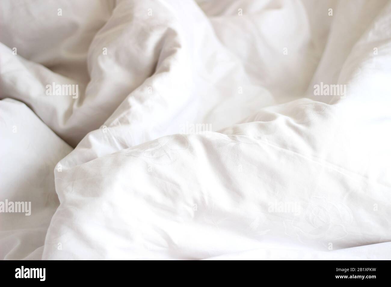 Soffici lenzuola bianche su un letto non fatto. Design Scandinavo Minimo. Concetto Di Hygge. Foto Stock