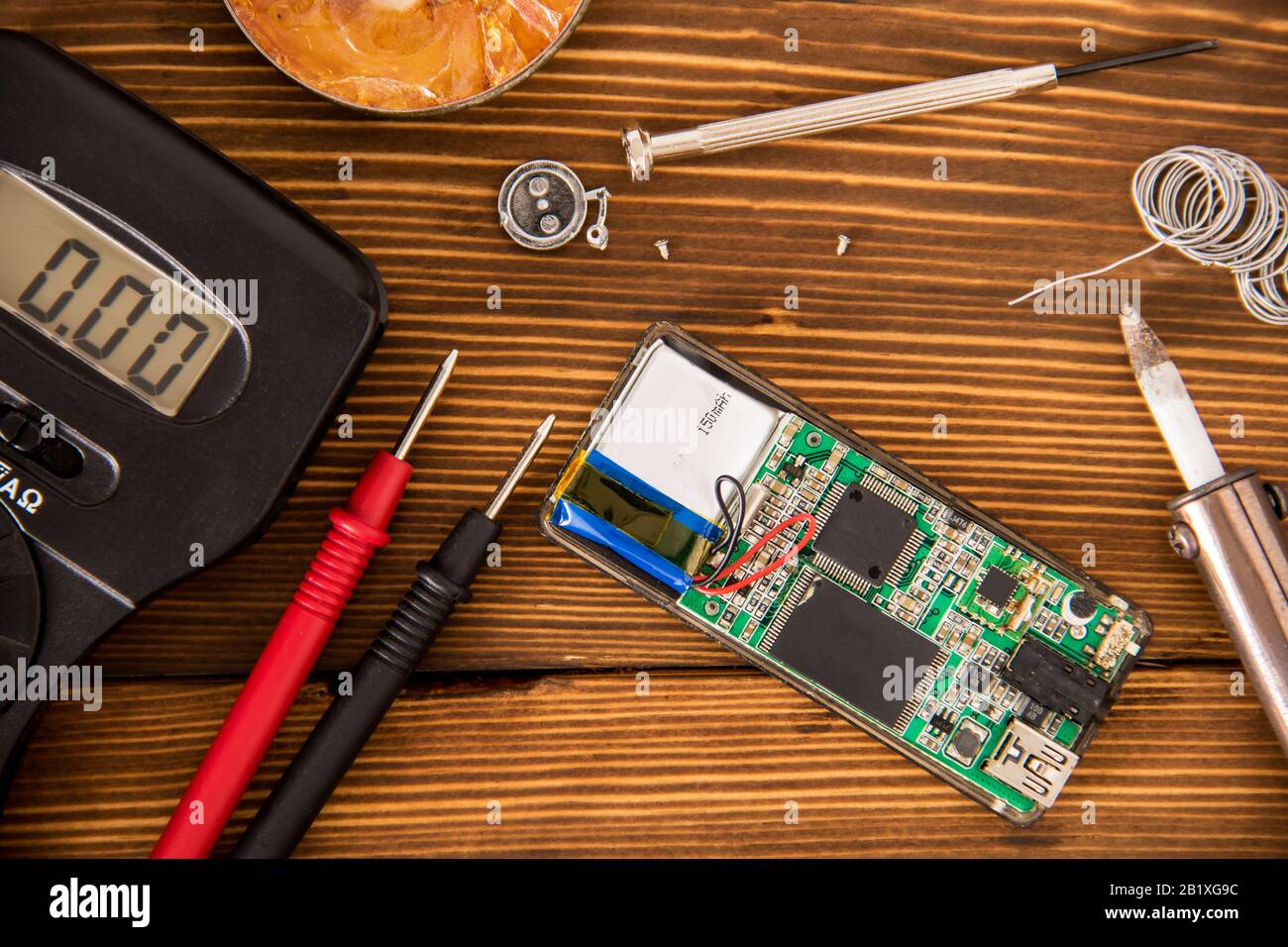 Set per saldatura filo e tubo di saldatura termoretraibile con saldatura accanto a cacciavite e multimetro su sfondo in legno, concetto di elettronica radio Foto Stock