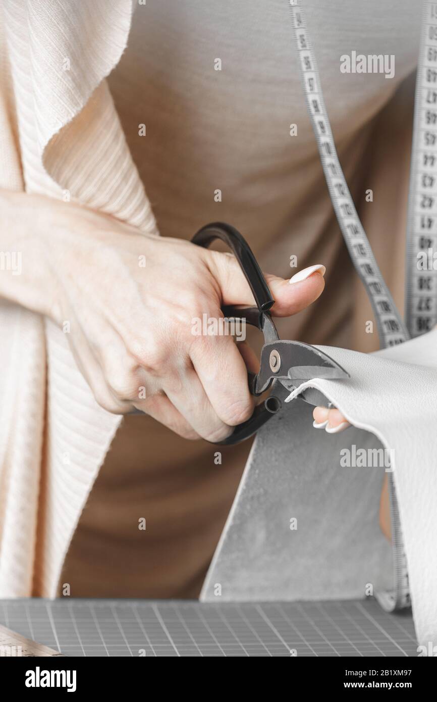 Borsa da donna designer che misura la pelle e taglia i dettagli in un laboratorio studio Foto Stock