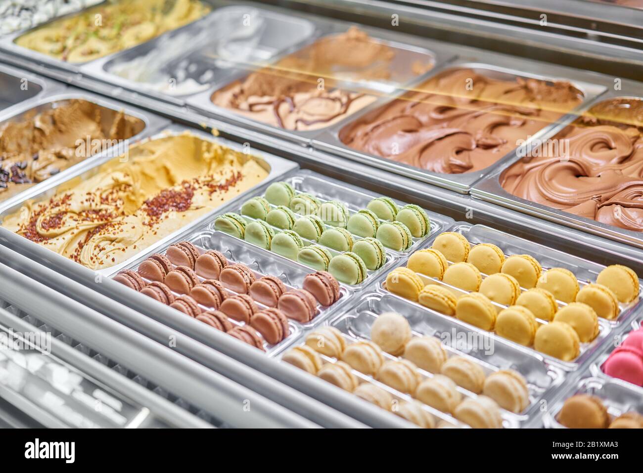 Assortimento di macaron colorati sulla vetrina dei caffè. Varietà di sapori macaron. Dolci di mandorle in negozio. Gelateria italiana. Foto Stock