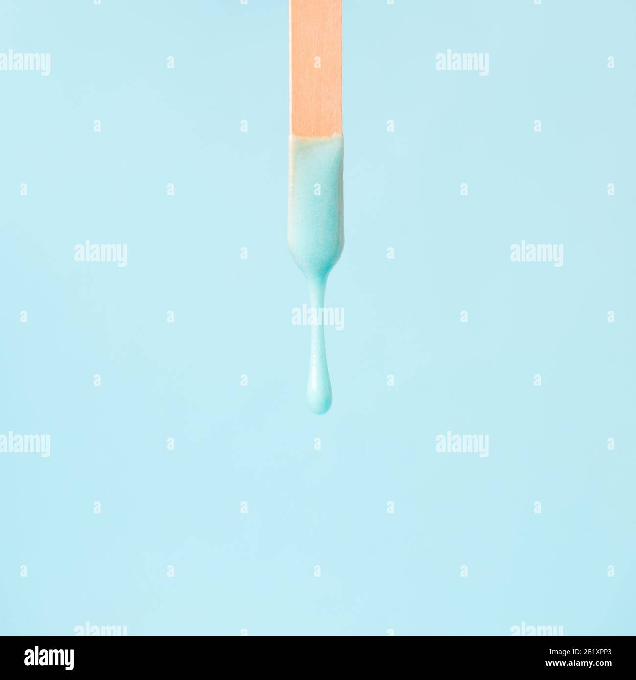 cera di menta liquida o pasta di zucchero per la depilazione scarica dal bastone su fondo di menta. Il concetto di depilazione, ceratura, pelle liscia zuccherata, bellezza Foto Stock