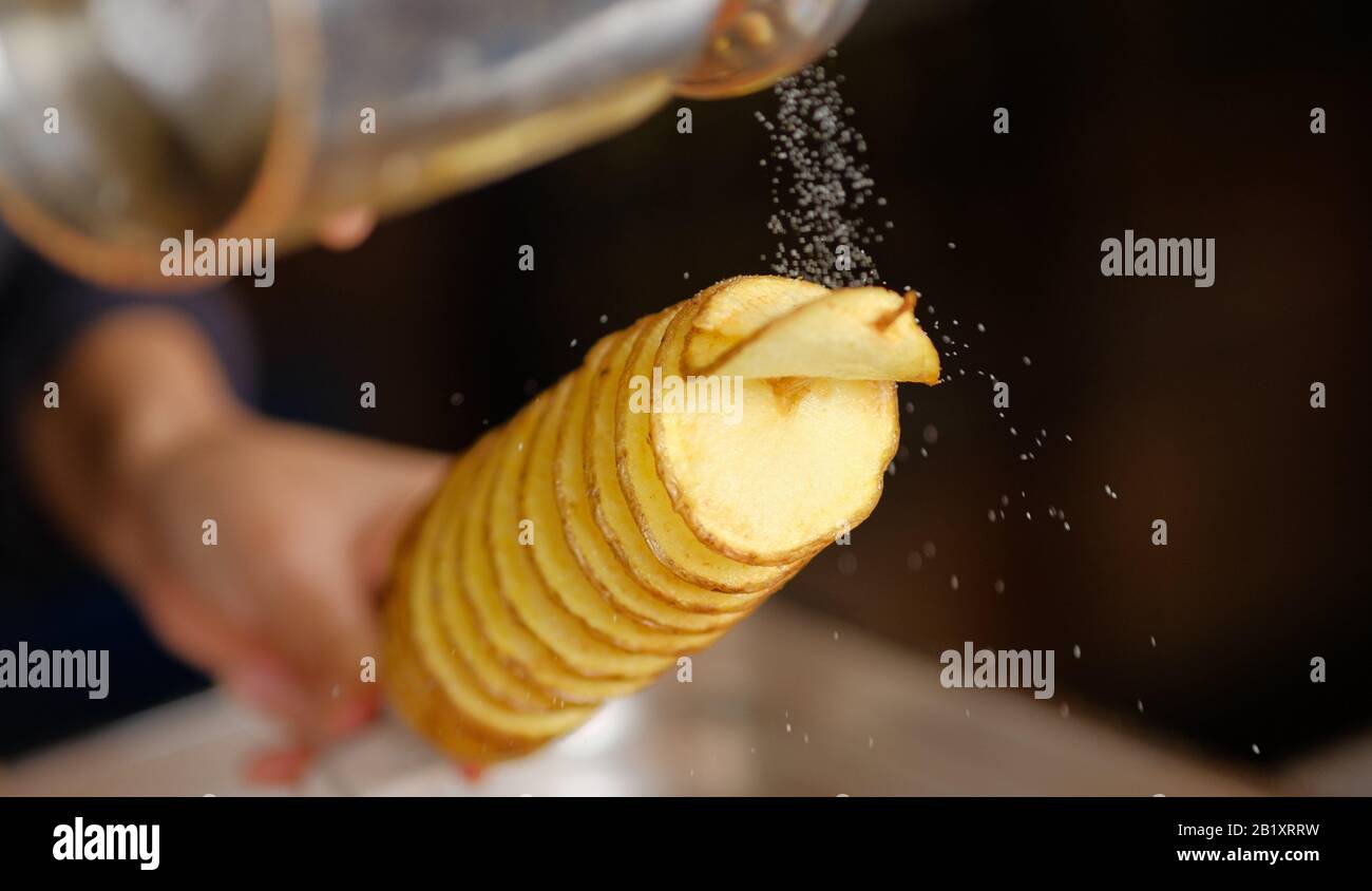 tornado potatoe su un bastone che viene salato in un negozio di cibo Foto Stock