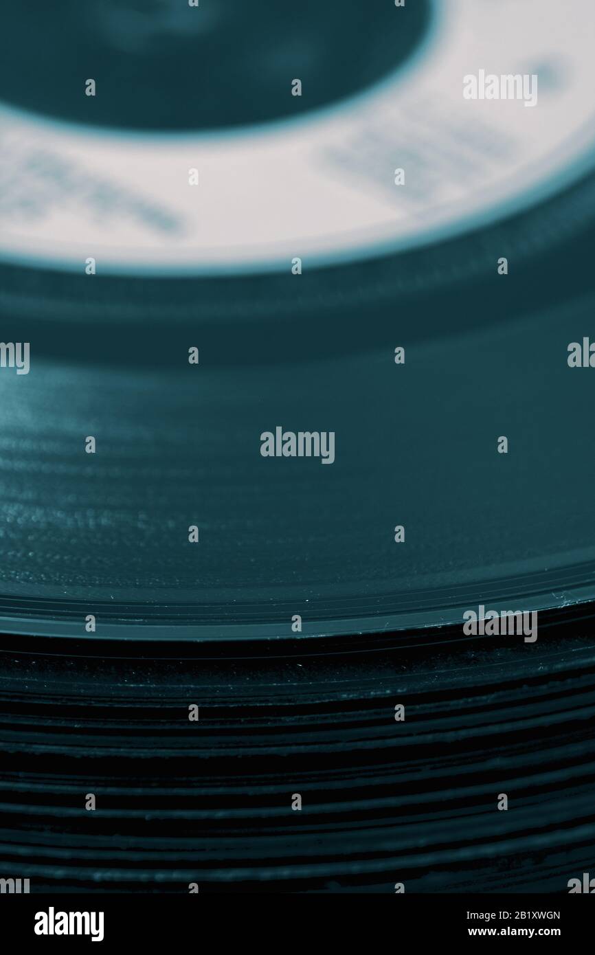 Dischi in vinile impilati l'uno sull'altro in una pila. Con tonalità di colore Foto Stock