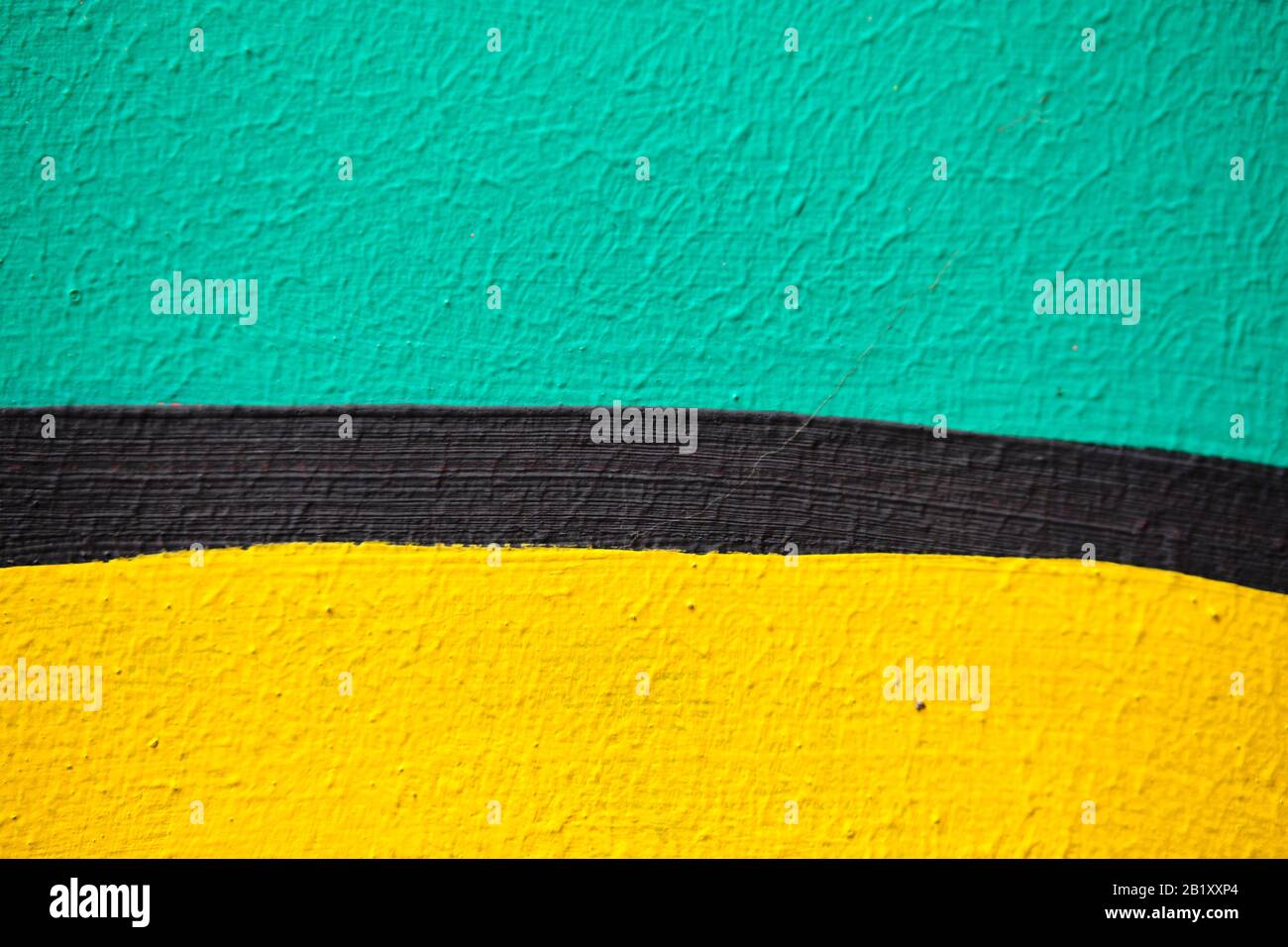 Intonaco astratto texture di verde, giallo con una striscia nera di colore. Primo piano. Foto Stock