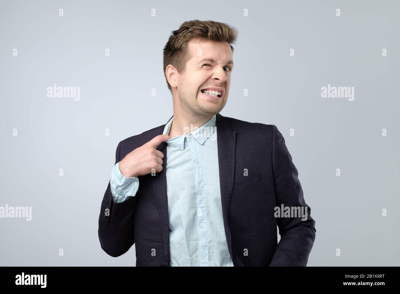 Sudorazione manager tirando la camicia con il dito sensazione di nervosismo e stress. Colletto stretto e concetto scomodo di vestiti. Foto Stock