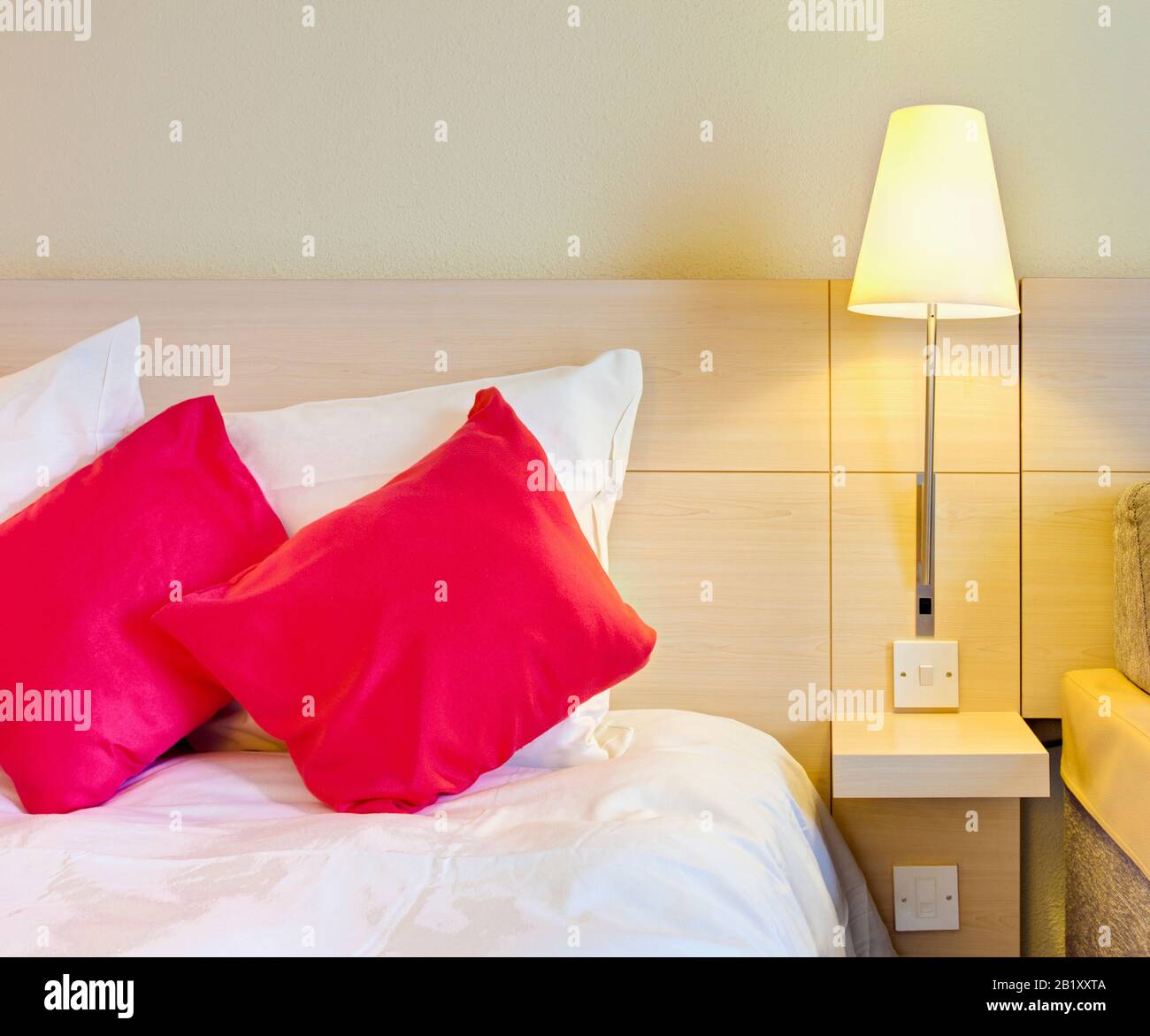 Camera d'albergo essenziale, letto con letto vicino al comodino, Inghilterra UK Foto Stock
