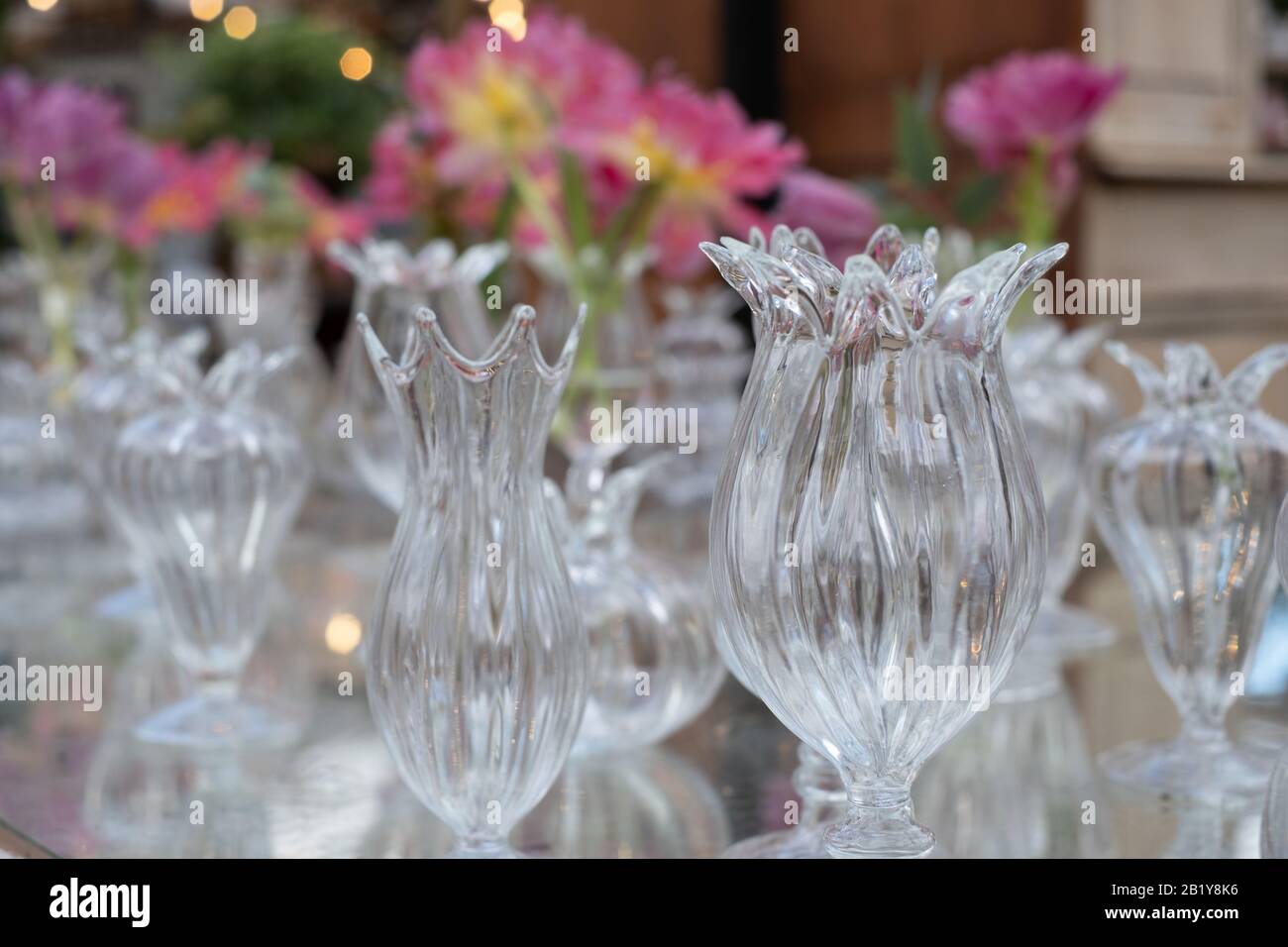 Tavolo decorato con fiori rosa azalea in vasi di cristallo di vetro. Foto Stock