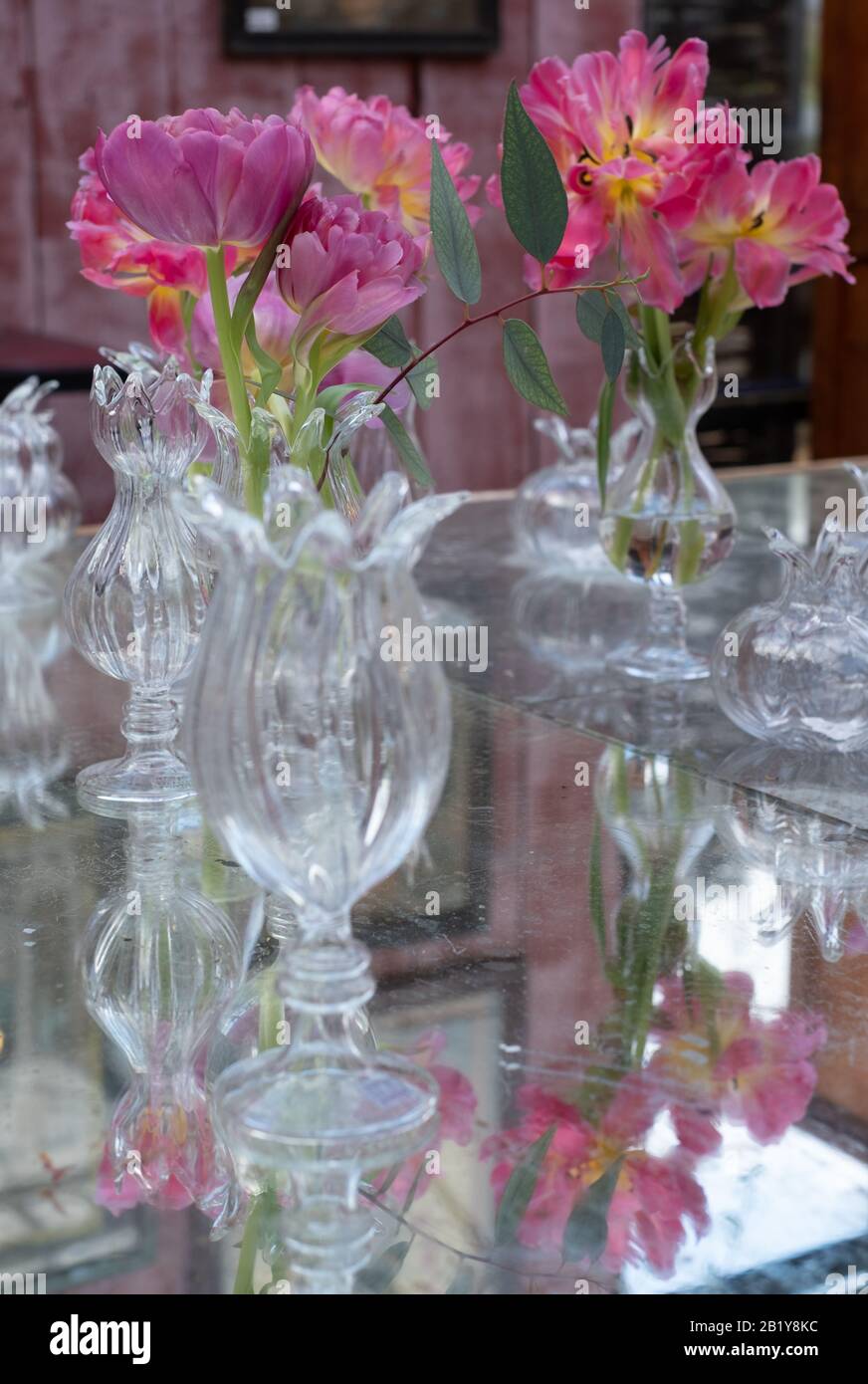 Tavolo decorato con fiori rosa azalea in vasi di cristallo di vetro. Foto Stock