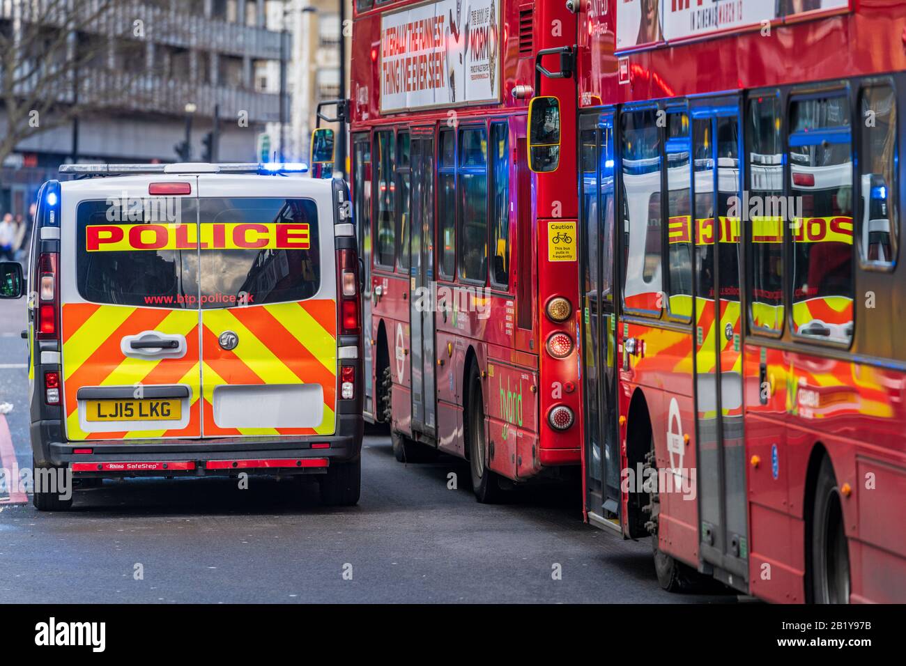 British Transport Police London - un furgone della polizia di trasporto britannico con le luci blu che lampeggiano i parchi accanto a due autobus di Londra nel centro di Londra Foto Stock