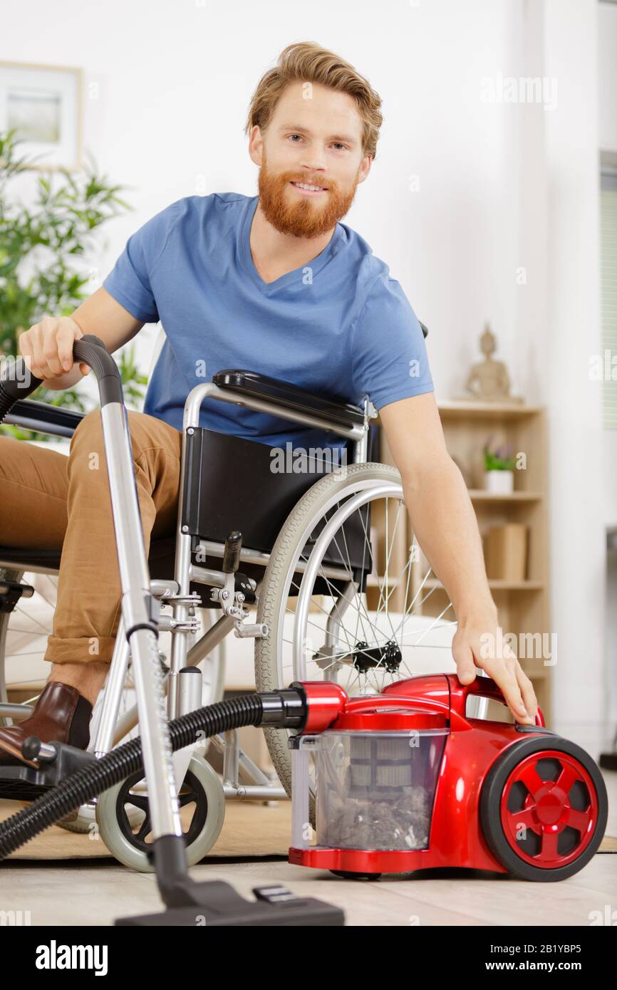 l'uomo disabile pulisce la sua casa Foto Stock