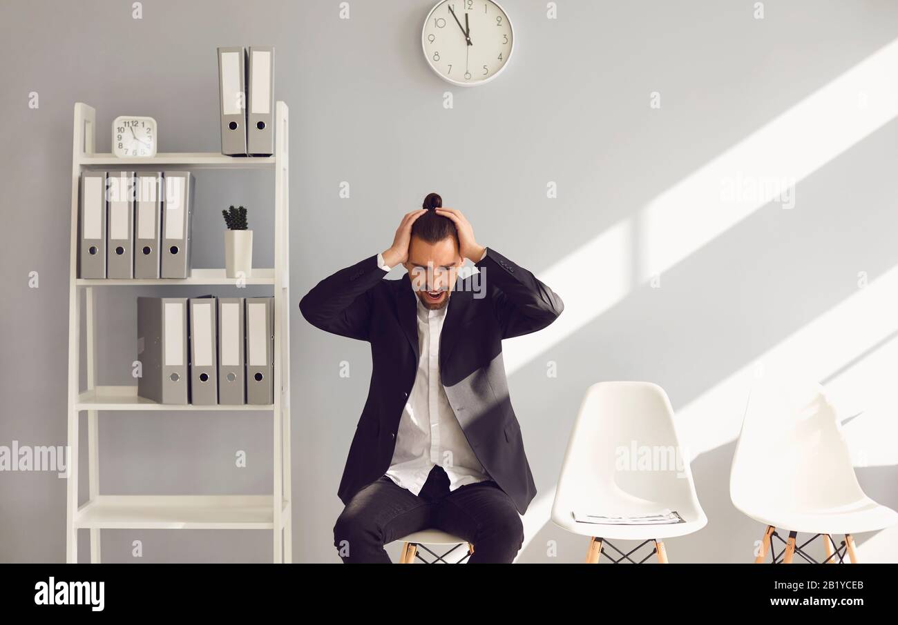 Una giovane brunetta tiene un curriculum nelle sue mani in attesa di una vista interna di un nuovo lavoro in ufficio. Foto Stock