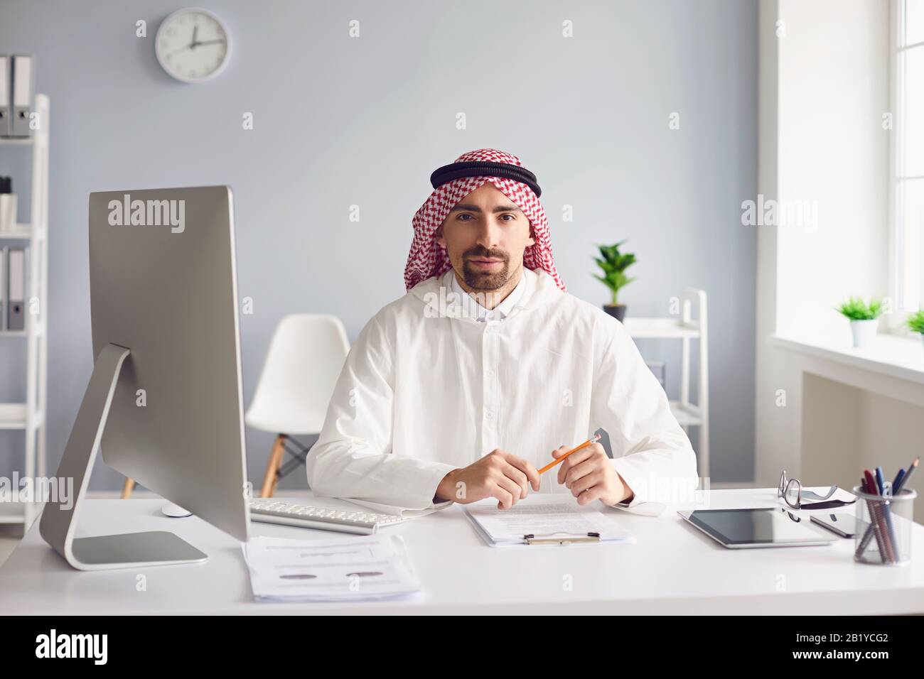 Il calmo uomo arabo siede ad un tavolo nell'ufficio. A. Foto Stock