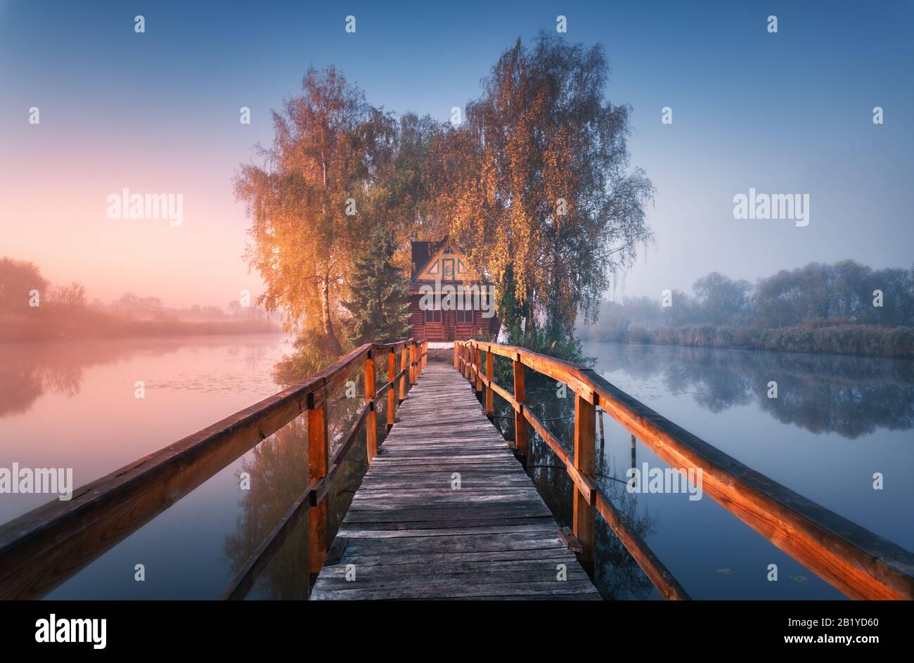 Vecchia casa di pescatori e molo di legno a nebbia mattina in autunno Foto Stock