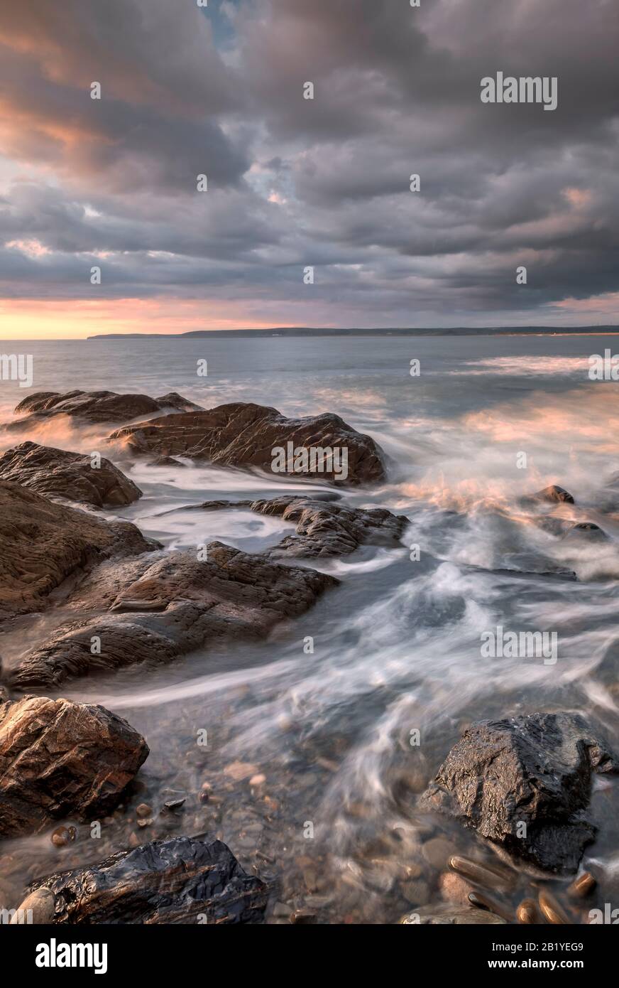 Cielo romantico e spettacolare al tramonto sul Devon settentrionale, spiaggia, costa, costa, costiero, costiero, stordimento, costa, rocce, riflessi, ciottoli, nuvole, Regno Unito Foto Stock